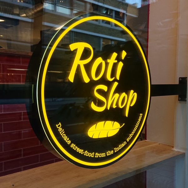 Lysskilt i vinduet til Roti Shop i Rådhusgata