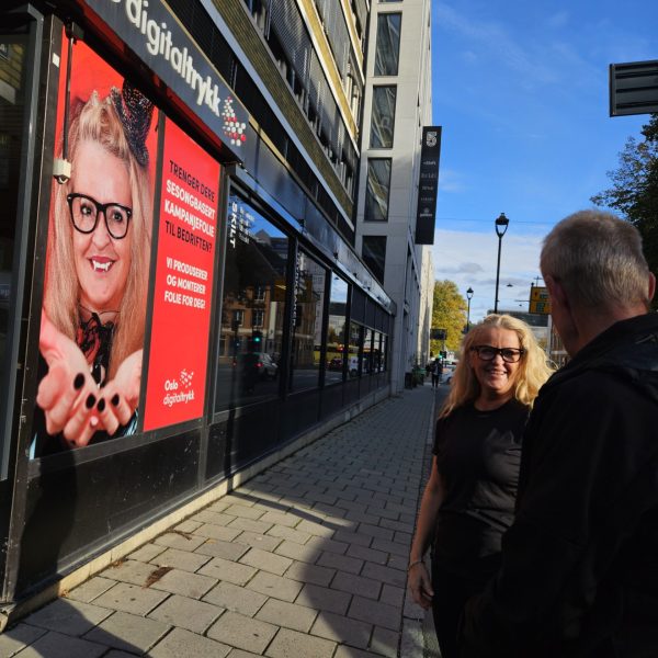 Trine og Jonny foran vår nye kampanjefolie som viser Trine som en liten vampyr.